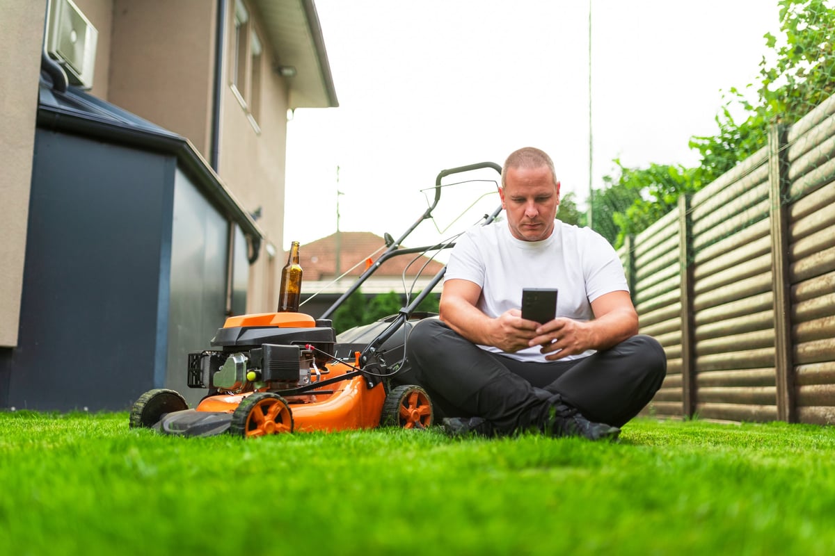 A homeowner taking a break in the yard after a good day of lawn care